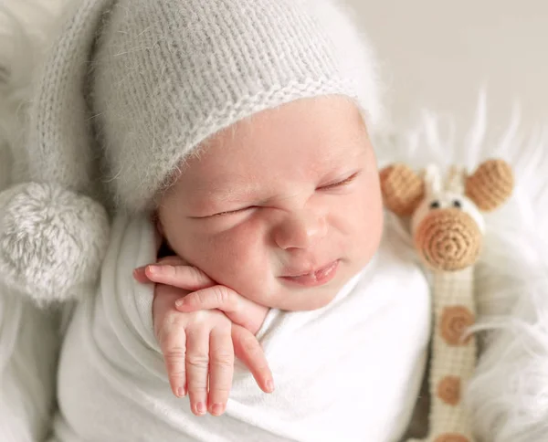 Kleine baby slapen in de mand met speelgoed — Stockfoto