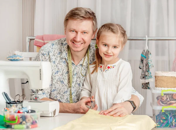 Kleines Mädchen und ihr Vater in einer Nähwerkstatt — Stockfoto