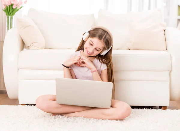 Schattige tiener meisje glimlachend op haar laptop — Stockfoto