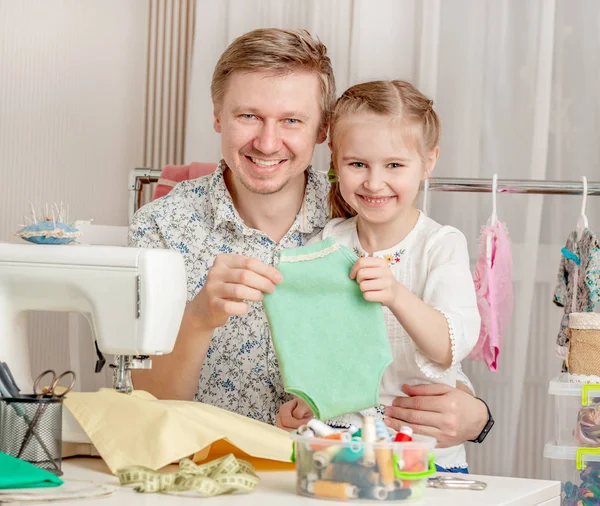Malá holčička a její otec v šicí dílně — Stock fotografie