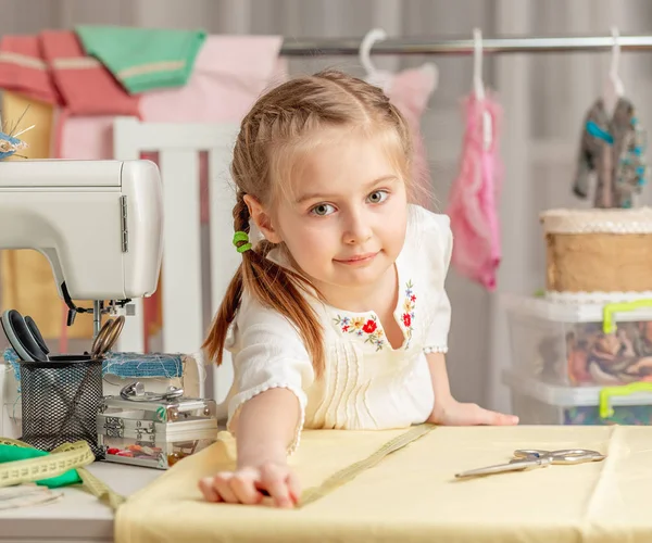 Klein meisje in een workshop naaien — Stockfoto