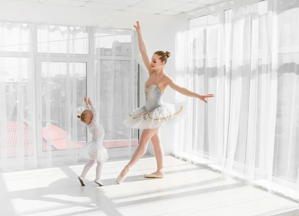 Giovane splendida ballerina con la sua piccola figlia che balla in studio — Foto Stock