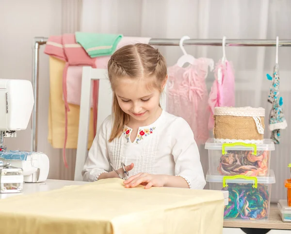 Klein meisje in een workshop naaien — Stockfoto