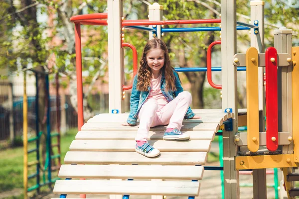 Μικρό κορίτσι παίζει σε μια σκάλα παιδική χαρά — Φωτογραφία Αρχείου