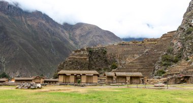 Ollantaytambo'da dağın altındaki taş kulübeler