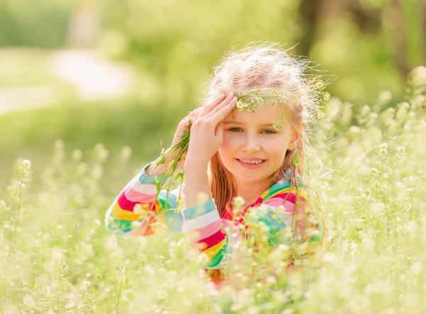 Child resting on green field — Stock Photo, Image