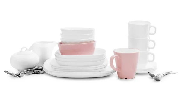 Белые и розовые пластины, сахарная чаша и кружки на светлом фоне — стоковое фото