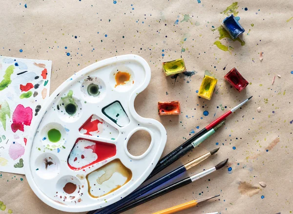 Paleta de arte com pincéis e caixas de pintura na mesa de oficina — Fotografia de Stock