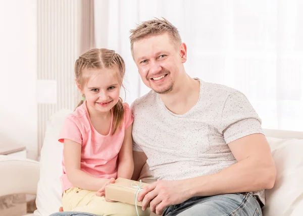 Papá con hija abriendo Regalo del día de los padres en el sofá — Foto de Stock