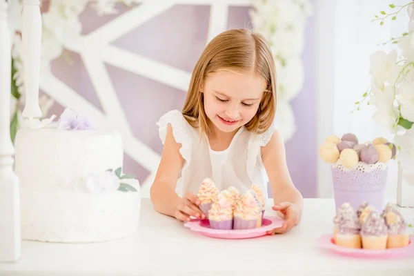 小女孩在糖果酒吧拿着一个粉红色的盘子和甜蛋糕 — 图库照片