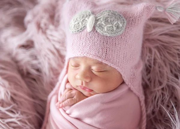 Recém-nascido em chapéu de gorro em um tapete desgrenhado — Fotografia de Stock