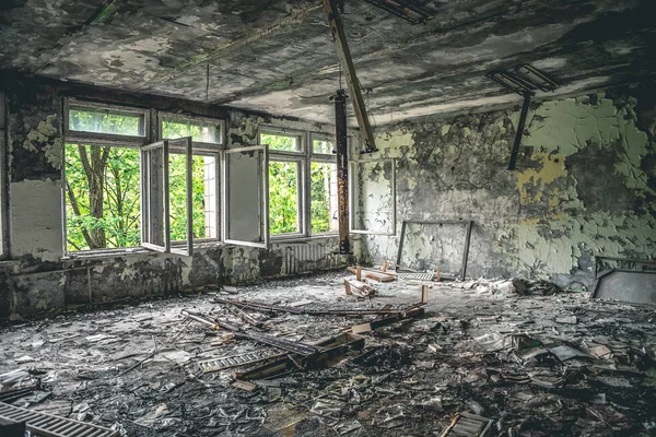 Ruined assembly hall with debris in abandoned Pripyat school — Stock Photo, Image