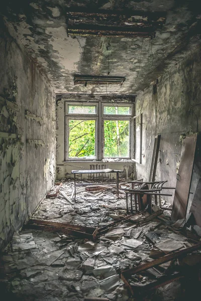 ruined class room with desks and blackboards in Pripyat school