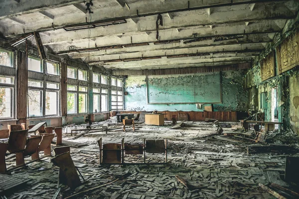 Ruined assembly hall with debris in abandoned Pripyat school — Stock Photo, Image