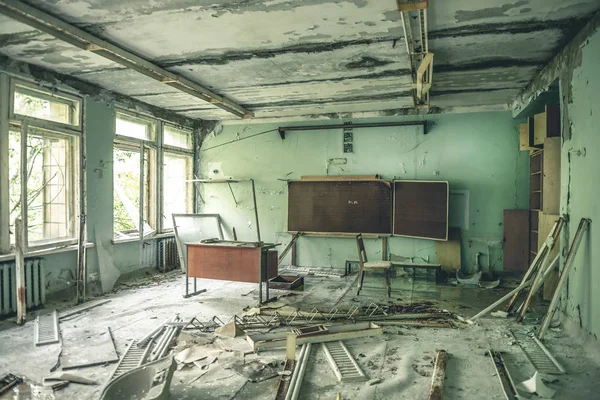 Sala de clase en ruinas con escritorios y pizarras en la escuela Pripyat — Foto de Stock