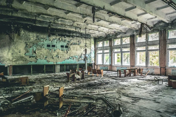 Ruined assembly hall with debris in abandoned Pripyat school — Stock Photo, Image