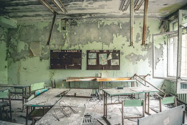 Salle de classe ruinée avec bureaux et tableaux noirs à l'école Pripyat — Photo