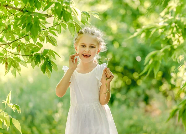 Niña recogiendo flores en el parque — Foto de Stock