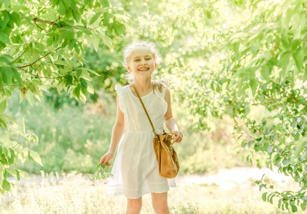 Leende liten flicka i arken med blomma — Stockfoto