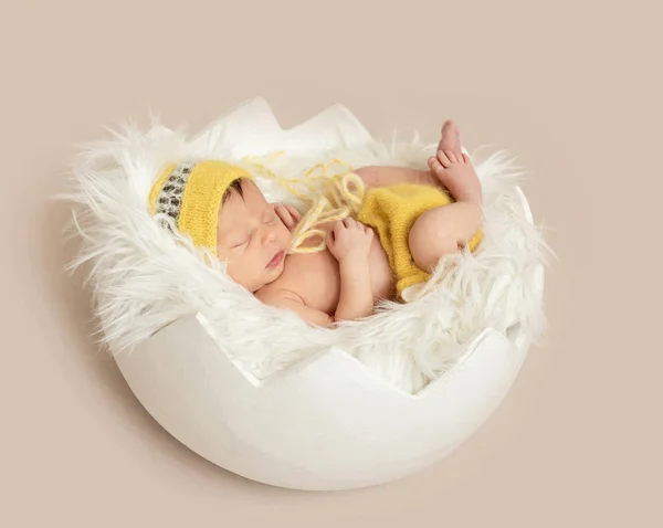 Drôle bébé endormi en barboteuse jaune sur lit rond — Photo