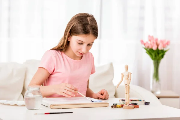 Mädchen zeichnet mit Farbe aus Figur — Stockfoto