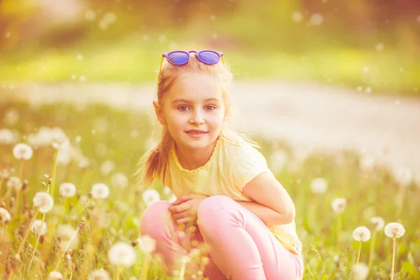 Hübsches Kind Gorl sitzt auf der grünen Wiese — Stockfoto