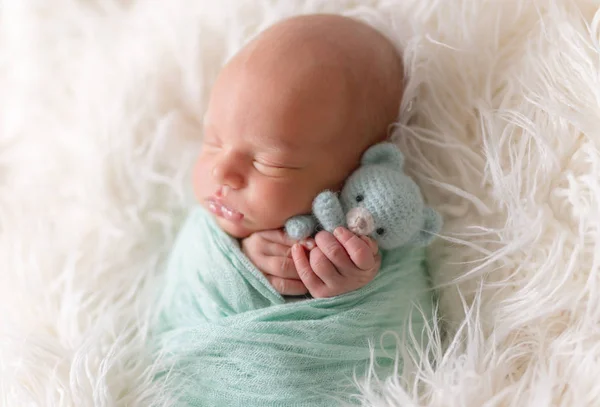 Neugeborenes Baby liegt mit Strickspielzeug — Stockfoto