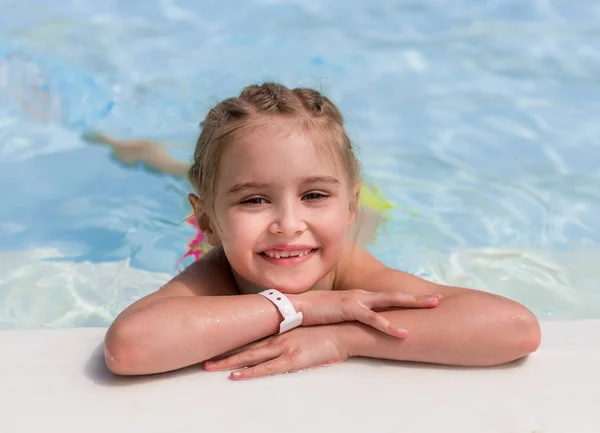 Lächelndes Mädchen schwimmt zum Pool — Stockfoto