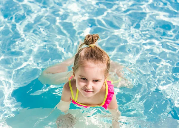 Lächelndes Mädchen schwimmt zum Pool — Stockfoto