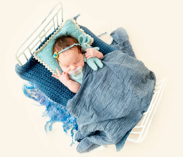 Newborn baby girl sleeping in a little bed — Stock Photo, Image