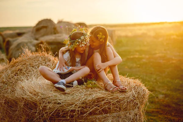 Lovely sisters smiling, on haystacks — Stock Photo, Image