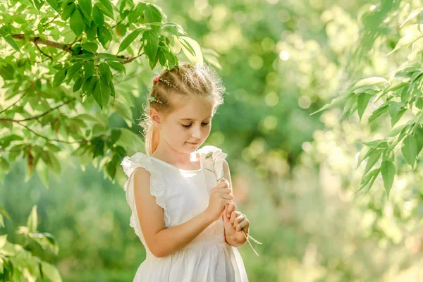 Liten flicka med vackra blommor — Stockfoto