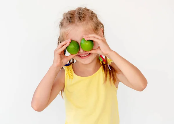 Kleines Mädchen mit frischen Limettenfrüchten — Stockfoto