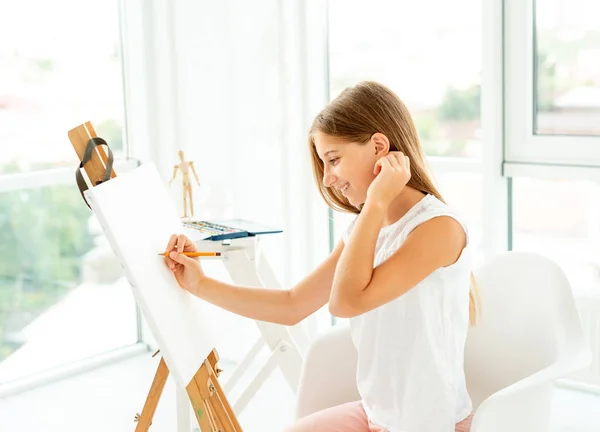 Teenager girl makes pencil sketch on canvas — Stock Photo, Image