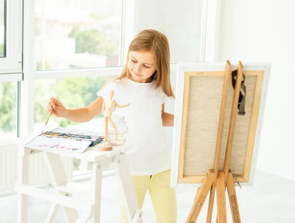 Nettes kleines Mädchen malt auf Leinwand — Stockfoto
