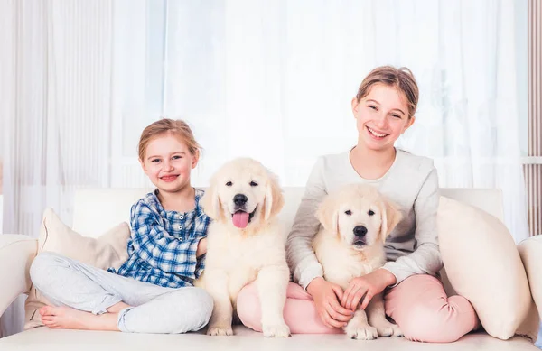 Lachende zussen zittend met puppy 's — Stockfoto
