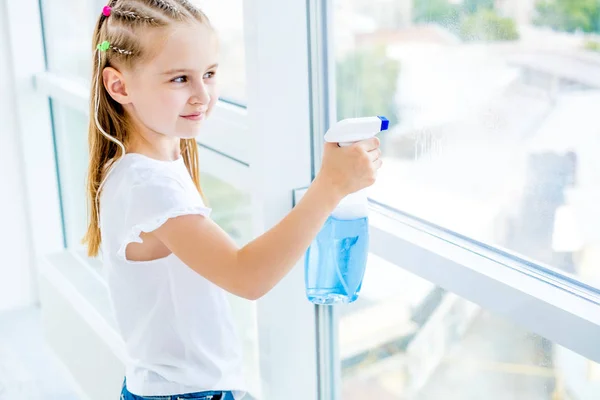 Little girl cleaning the window — Stock Photo, Image