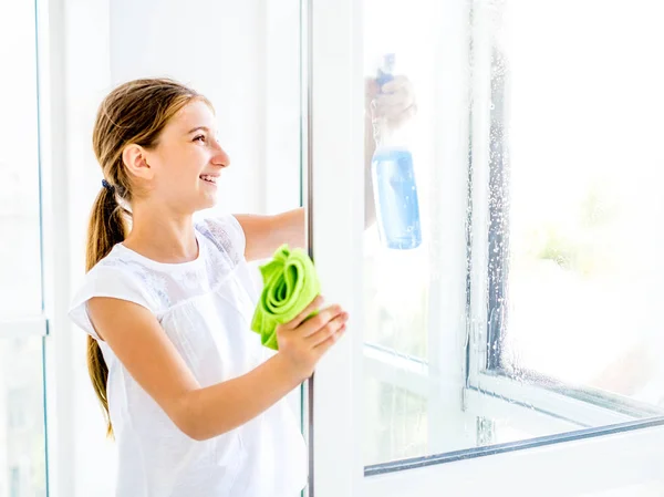 Chica adolescente ventana de limpieza con spray —  Fotos de Stock