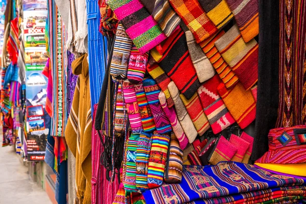 Een heleboel verschillende kleurrijke stof dekbedden op de souvenir winkel in Bolivia — Stockfoto