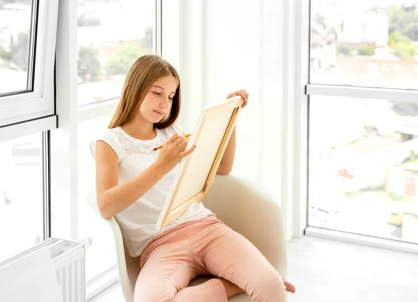 Schattig tiener meisje tekenen met potlood in de stoel — Stockfoto