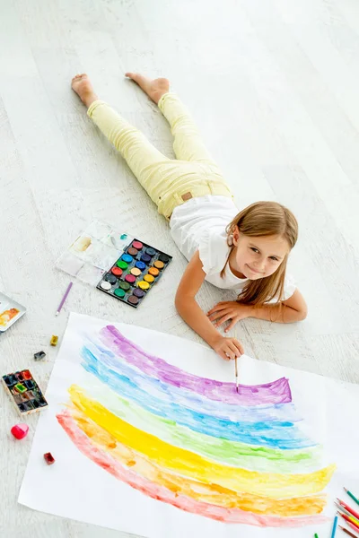 Menina desenha deitado no chãopequena menina alegre desenha deitado no chão — Fotografia de Stock