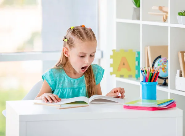 Nettes Mädchen liest Bücher auf der Schulbank — Stockfoto