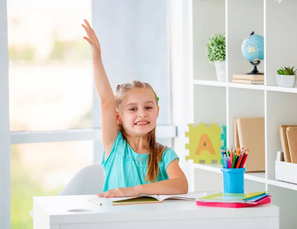 Beatiful bambina alzato la mano in classe — Foto Stock