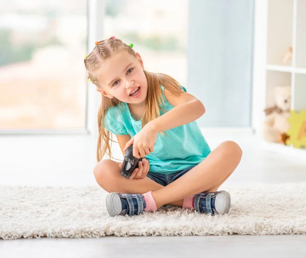 Söt barnflicka som spelar video spel på konsolen — Stockfoto