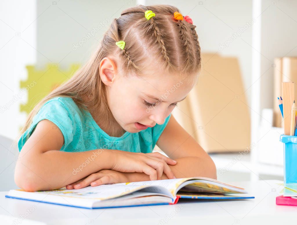 Cute schoolgirl reading book, closeup