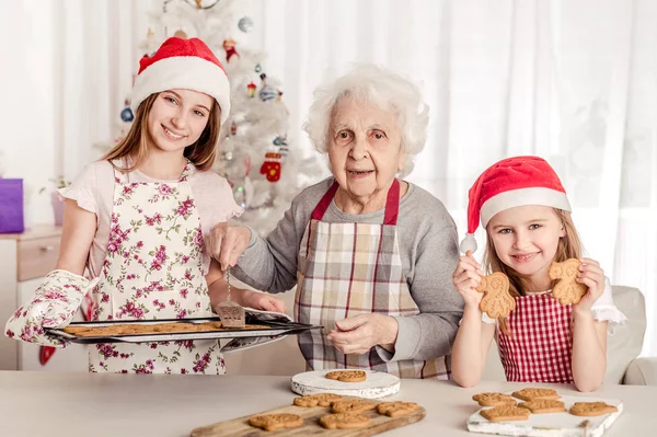 Grootmoeder met kleindochters bakken koekjes — Stockfoto