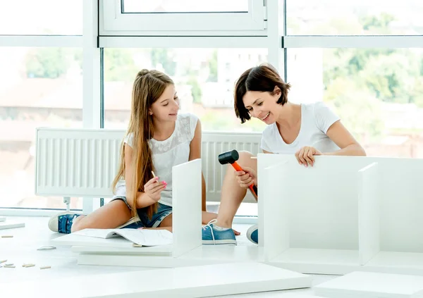 Família bonito montagem marca nova estante — Fotografia de Stock