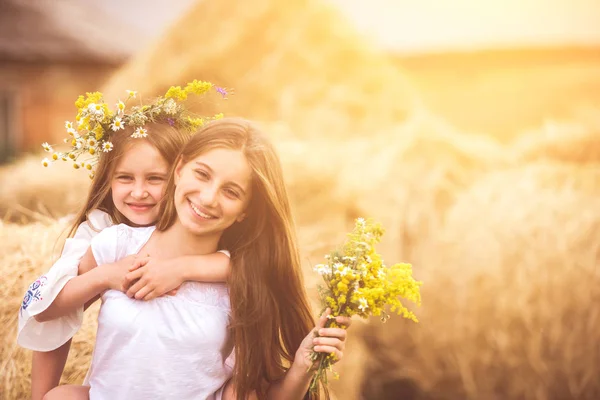 Dwie słodkie siostry z kwiatami — Zdjęcie stockowe