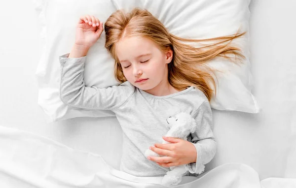 Menina dormindo na cama branca — Fotografia de Stock