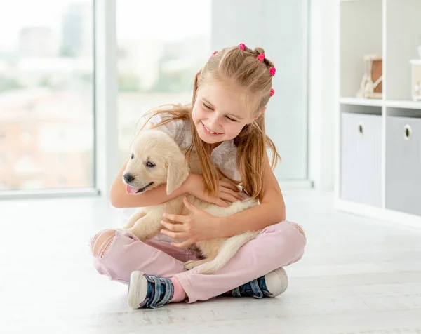 Kleine meid knuffelen retriever puppy — Stockfoto